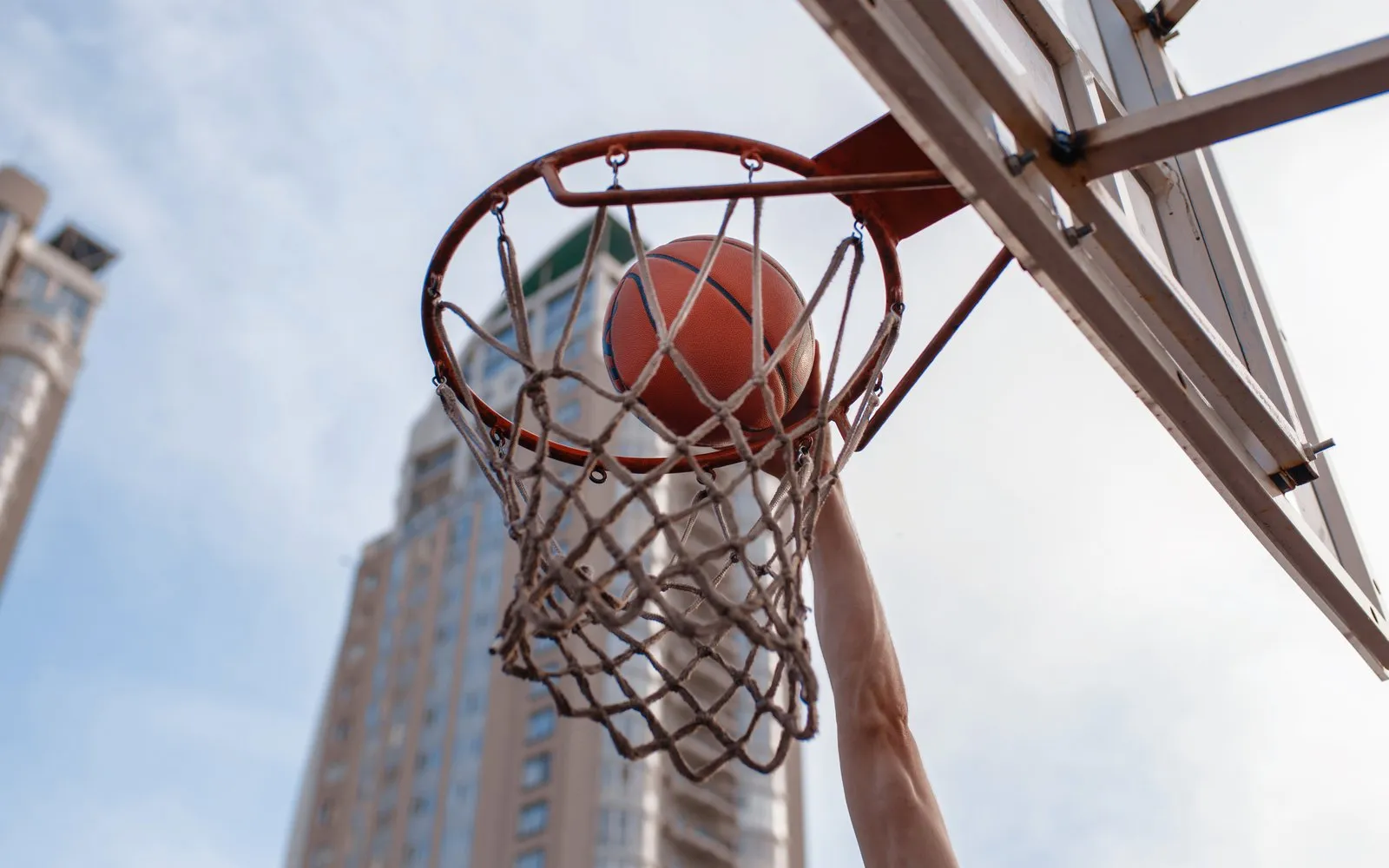 A basketball dropping through a hoop against a city skyline